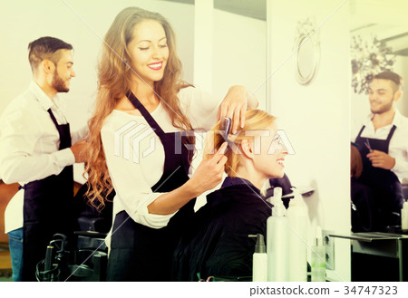 Hairdresser styling hair 34747323