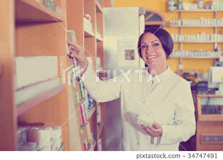 Smiling mature woman seller in uniform Smiling mature woman seller in uniform 34747491