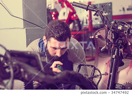 Worker repairing motorbike 34747492