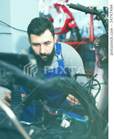 Worker repairing motorbike 34747494