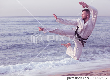 Cheerful man practising karate kata poses 34747587