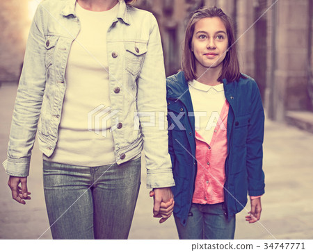 Mother and daughter walking 34747771