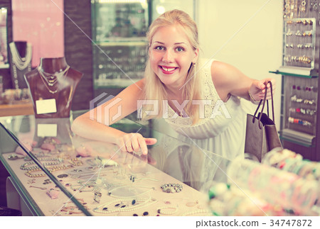 girl near glass showcase in bijouterie store . 34747872
