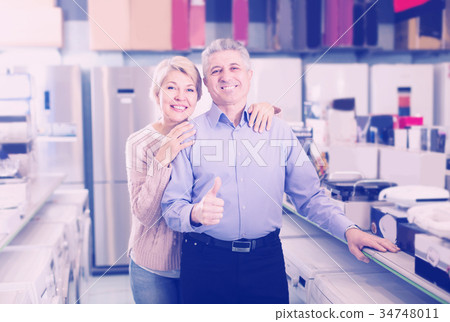 Adults are visiting shop of household appliances for buying goods Adults are visiting shop of household appliances for buying goods 34748011