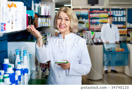 Portrait of two friendly glad smiling pharmacists working Portrait of two friendly glad smiling pharmacists working 34748120