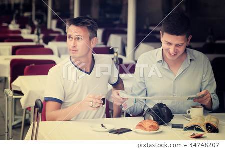 Men looking at map and drinking coffee with bakery Men looking at map and drinking coffee with bakery 34748207