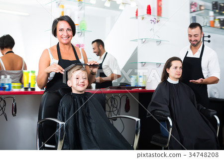 Smiling kid getting hair cut 34748208