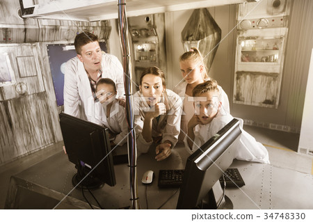 Parents with children are using PC in the quest room 34748330