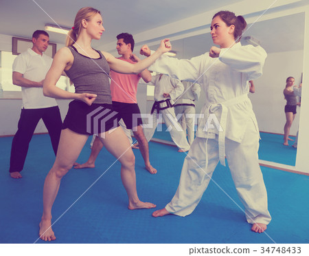 Adults are practicing new karate moves in pairs 34748433