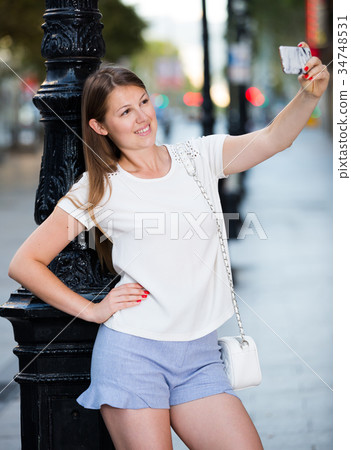 Girl taking selfie near old iron lamp post 34748531