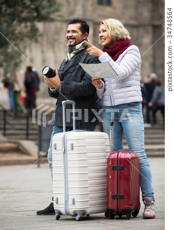 couple with suitcases, camera and map outdoors 34748564