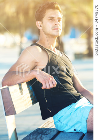 Sporty man resting on bench after workout 34748570