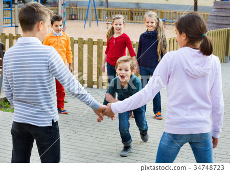 Junior school girls and boys playing octopus tag 34748723