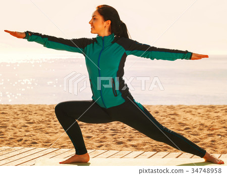 Charming young girl training yoga poses Charming young girl training yoga poses 34748958