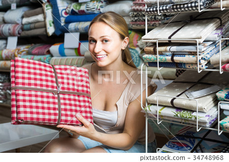 portrait of female customer choosing tablecloths in home textile section in shop portrait of female customer choosing tablecloths in home textile section in shop 34748968