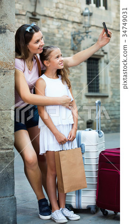 Woman with little daughter traveling together, taking selfie Woman with little daughter traveling together, taking selfie 34749031