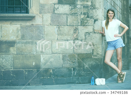 Young woman on old stone wall background Young woman on old stone wall background 34749186