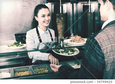 Girl and satisfied customer buying kebab 34749420