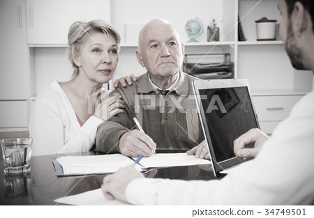 couple signing papers in bank 34749501