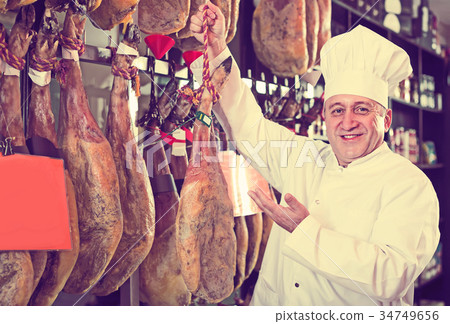 seller in deli shop with iberico and serrano jamon seller in deli shop with iberico and serrano jamon 34749656