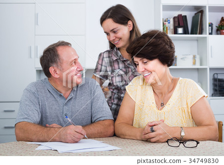Daughter helping her senior parents to do paperwork 34749830