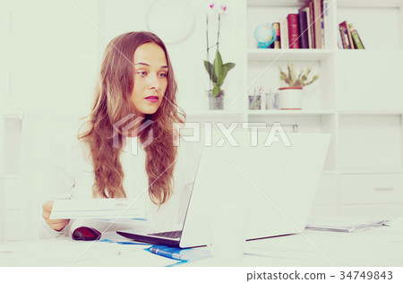 young woman at the table in office. 34749843