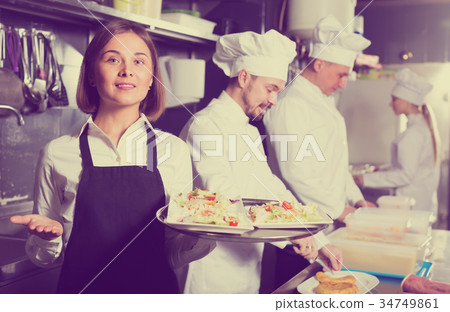 Laughing female waiter taking ordered dishes 34749861