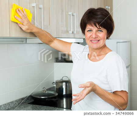 retiree woman cleaning home retiree woman cleaning home 34749866