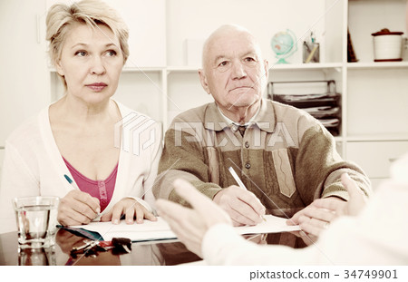 couple signing papers in bank couple signing papers in bank 34749901