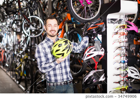 Man considering the range of helmets 34749906