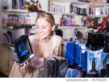 adult girl choosing toys in sex shop. adult girl choosing toys in sex shop. 34750229