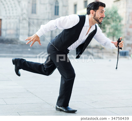 Expressive man running past old city 34750439