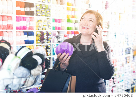 Senior female using smartphone after shopping Senior female using smartphone after shopping 34750468