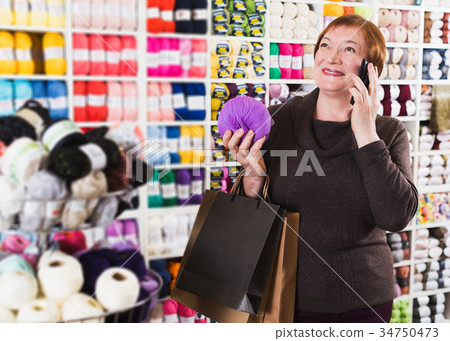 Woman with shopping bags using phone Woman with shopping bags using phone 34750473