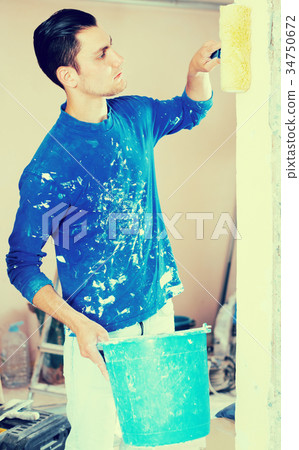 Construction worker applying prime coating 34750672