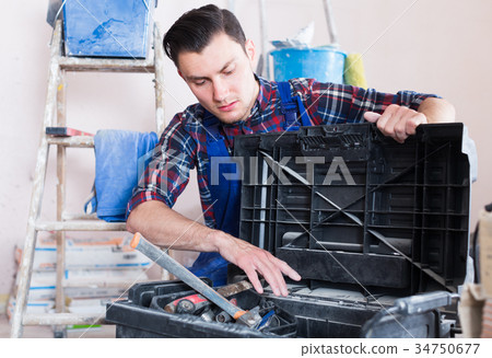 Worker looking fo tool in toolbox Worker looking fo tool in toolbox 34750677