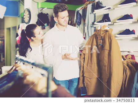 loving couple deciding on warm suit in sports store 34750813