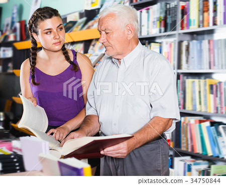 Joyful old man with girl are reading books Joyful old man with girl are reading books 34750844