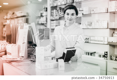 Female pharmacist offering help in choosing at counter in pharmacy 34750913