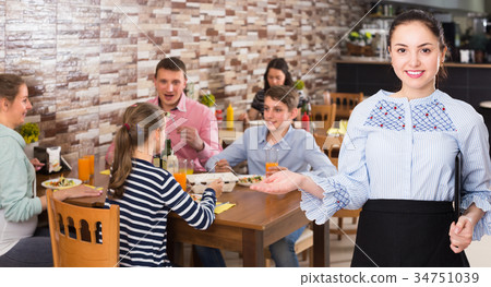 Professional waitress holding tray with dishes meeting visitors 34751039