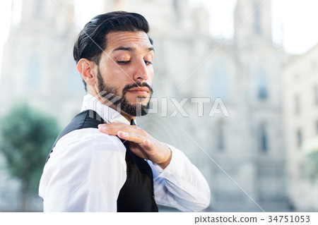 Smartly dressed man shaking dust off shoulder Smartly dressed man shaking dust off shoulder 34751053