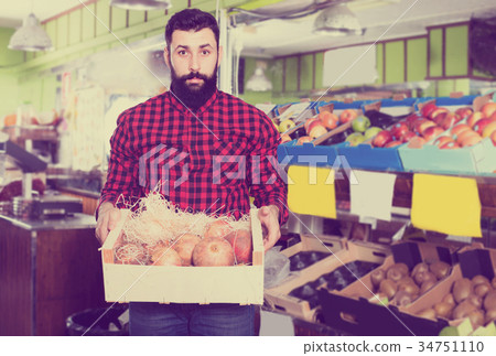 Smiling man seller showing pomegranates 34751110