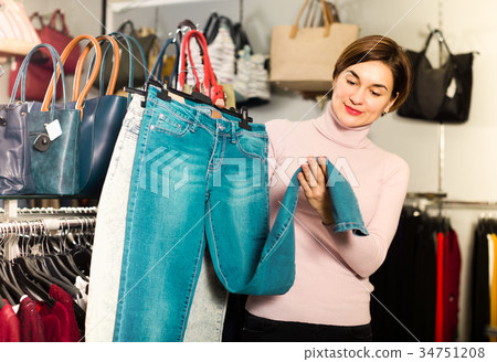 Customer is choosing new jeans Customer is choosing new jeans 34751208