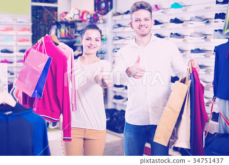 Young loving couple showing items they bought Young loving couple showing items they bought 34751437