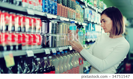 Woman choosing refreshing beverages in supermarket Woman choosing refreshing beverages in supermarket 34751547