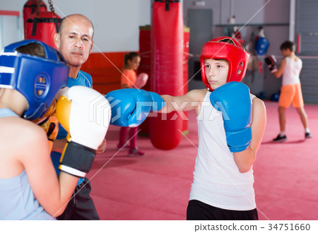 Cheerful teenagers practicing boxing punches Cheerful teenagers practicing boxing punches 34751660