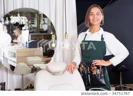 Smiling adult female professional visagiste standing Smiling adult female professional visagiste standing 34751767