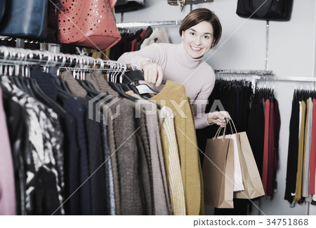 Brunette woman choosing turtleneck sweater 34751868