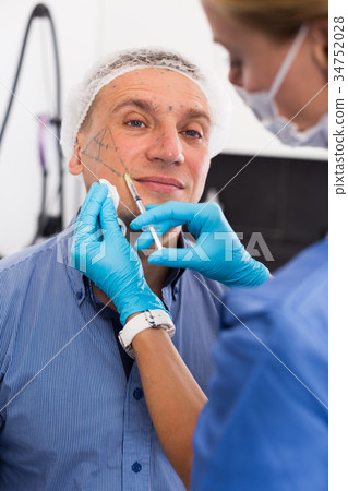 Female specialist is doing injection to client for anti-aging Female specialist is doing injection to client for anti-aging 34752028