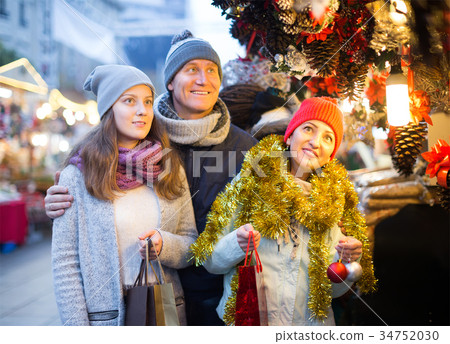 Happy married couple with a teenage daughter at Christmas market Happy married couple with a teenage daughter at Christmas market 34752030